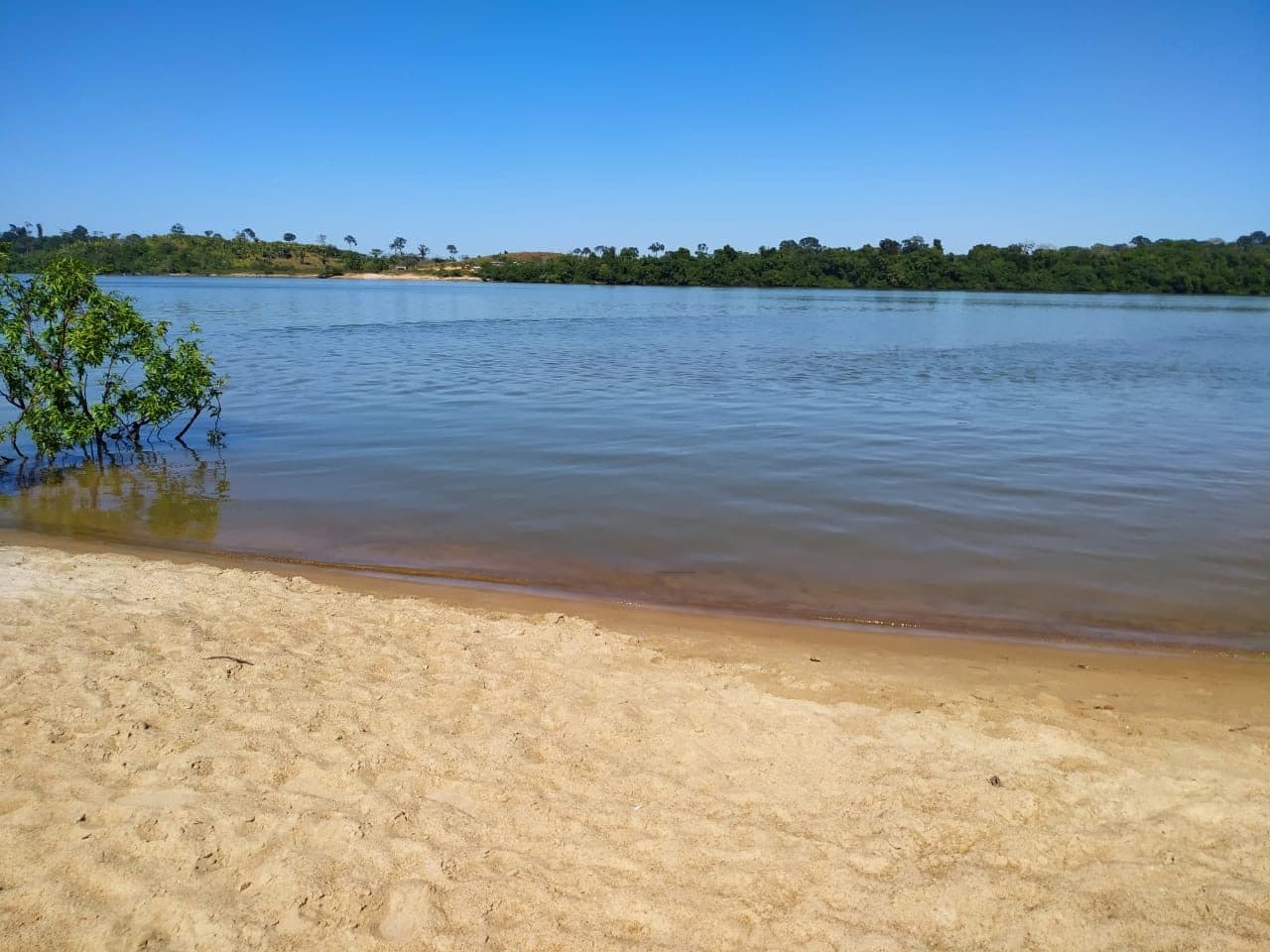 Une plage de sable au bord du Xingu : l'eau claire laisse voir le fond.